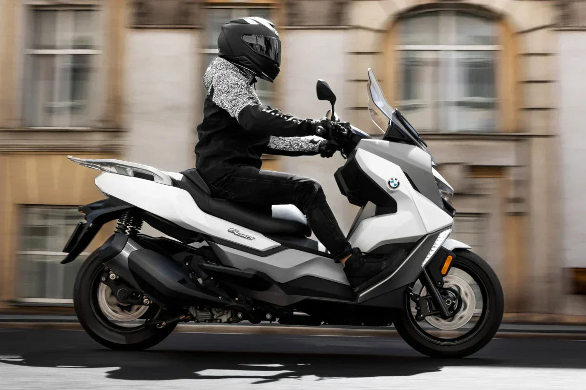 człowiek jedzie na skuterze 125 marki BMW