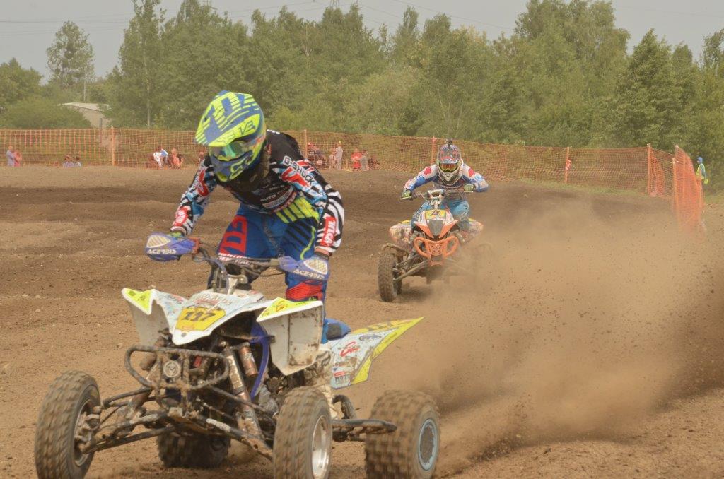 zawodnicy ścigający się na motocrosswym torze na quadach