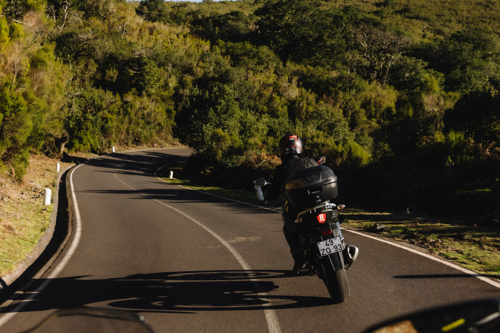 widok na motocyklistę podczas jazdy na motorze na drodze asfaltowej