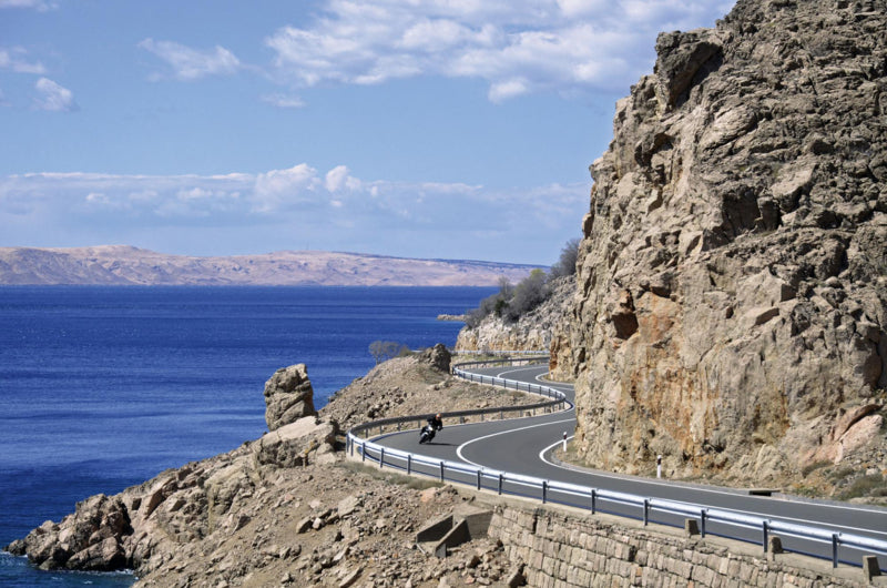 Widok słynnych chorwackich serpentyn motocyklowych, upał, błękitne niebo i sporo skał