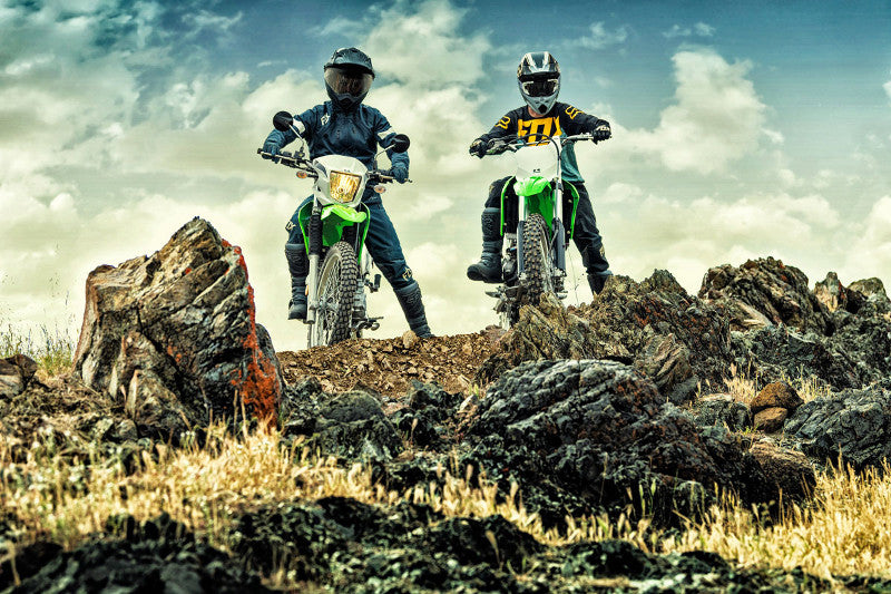 dwóch motocyklistów na skałach na motocyklach Kawasaki