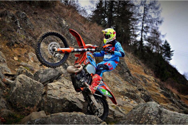 Motocyklista na motocyklu na drodze kamienistej w górach