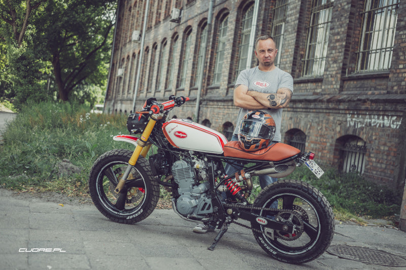 mężczyna obok motocykla w kolorze pomarańczowym