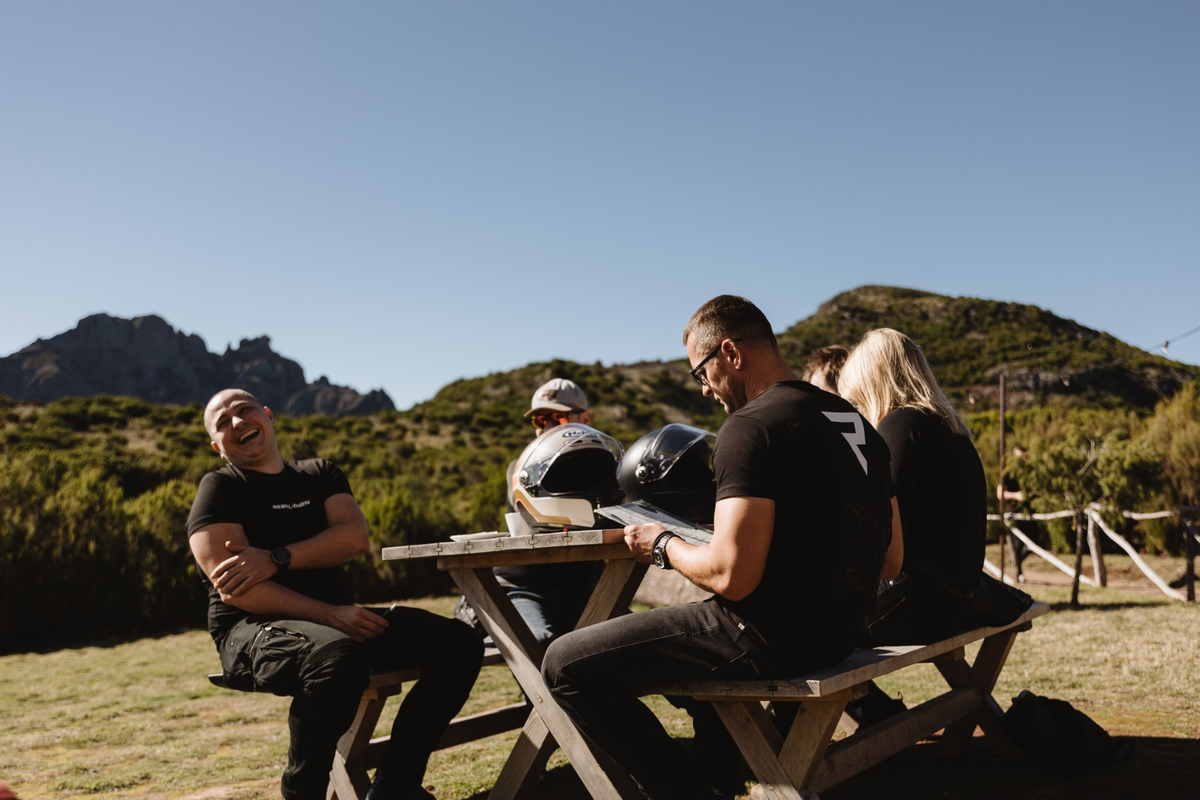 motocykliści siedzący na przy ławkach z kaskami