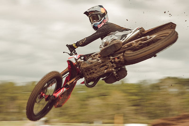 zawodnik motocross skaczący na motocyklu, ubrany w odzież i kask Fox