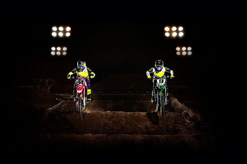 dwóch motocyklistów jadących nocą po oświetlonym torze w ubraniach z limitowanej kolekcji fox flexair honr