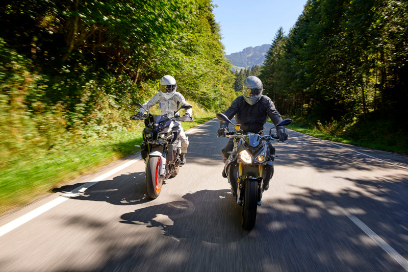 motocykliści jadą drogą asfaltową w odzieży Held