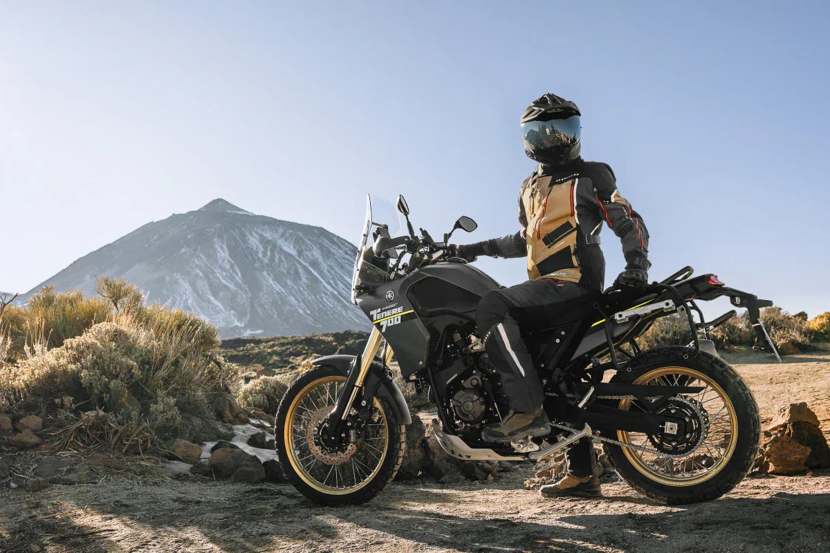 motocyklista siedzący na motorze na trasie górskiej