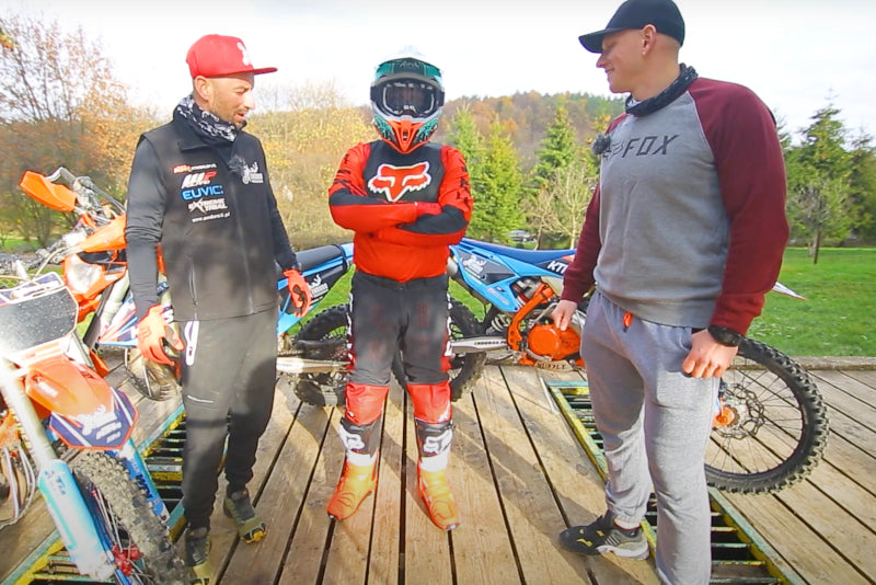 Zdjęcie 3 mężczyzn stojących w otoczeniu motocykli enduro, jeden ubrany w strój na offroad