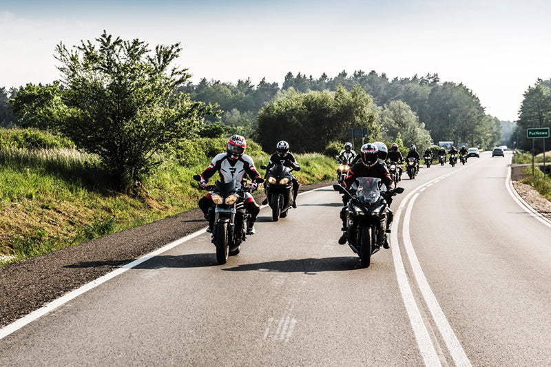 zdjęcie motocyklistów jadących po szosie na różnych rodzajach motocykli
