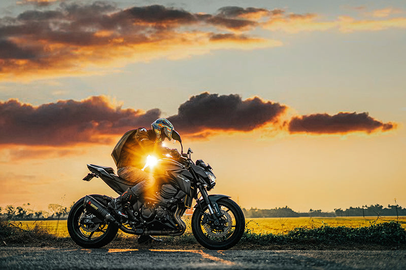 Motocyklista na motorze w kolorze czarnym przy zachodzie słońca