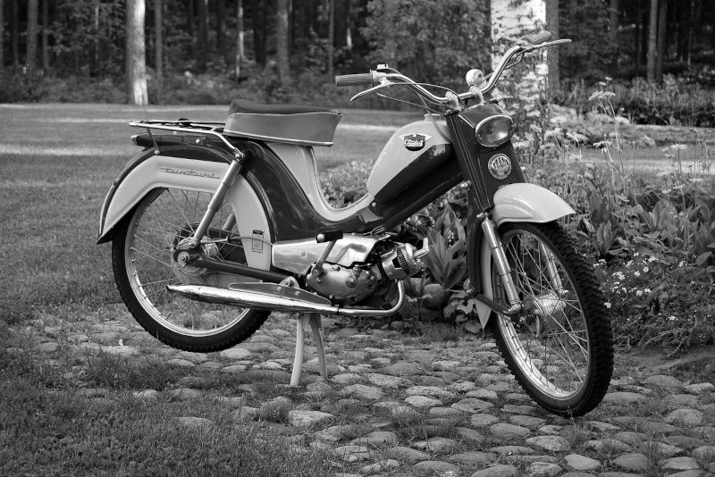 klasyczny motorower na czarno-białym zdjęciu