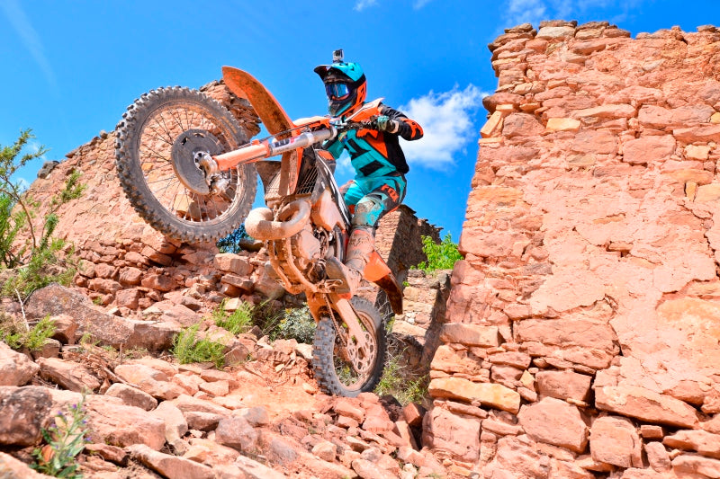 motocyklista enduro wyjeżdża ze zniszczonych zabudowań