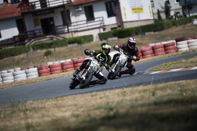 dwóch motocyklistów jedzie po torze na pit bike'ach