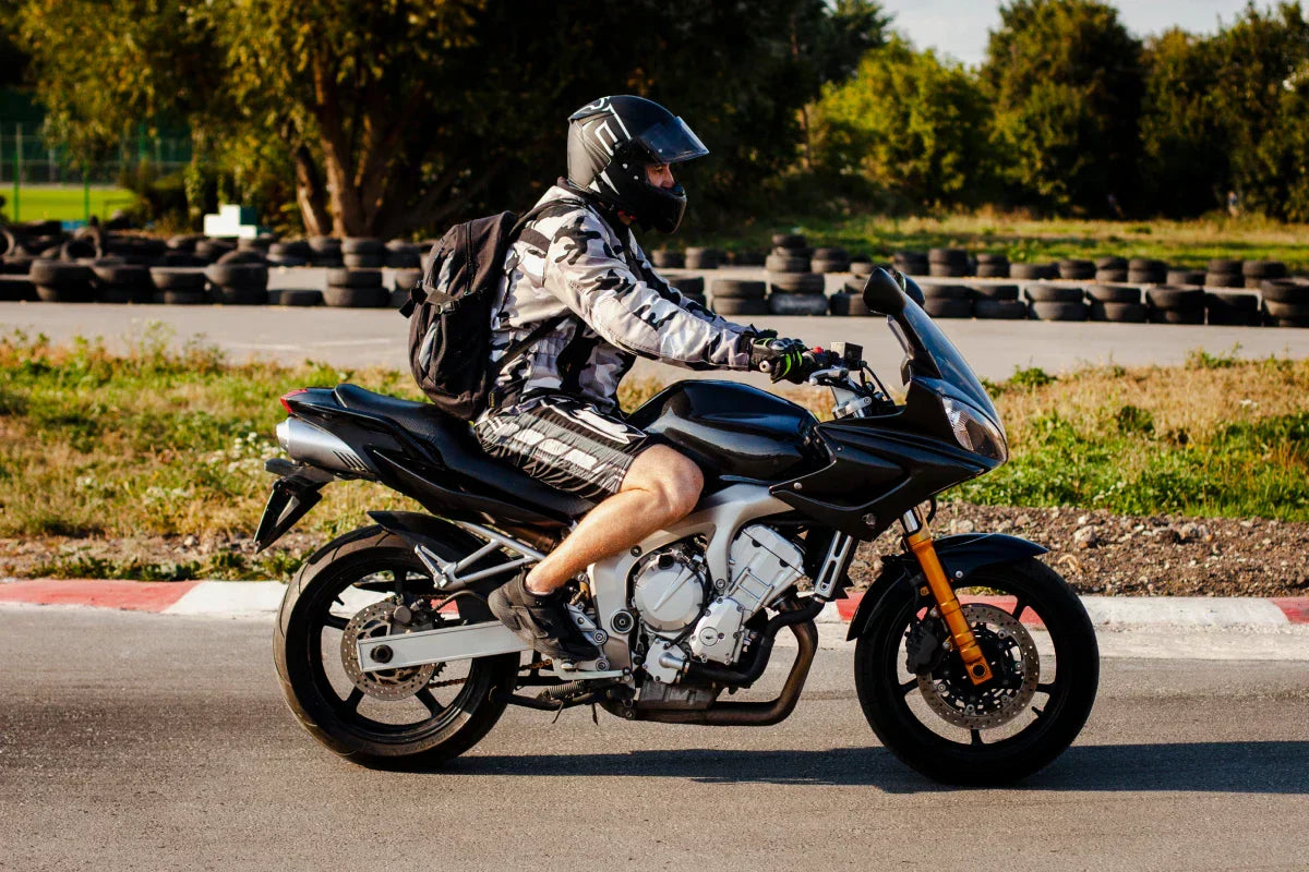 obrazek ilustruje motocyklistę, który nie jest odpowiednio ubrany na wyprawę motorem