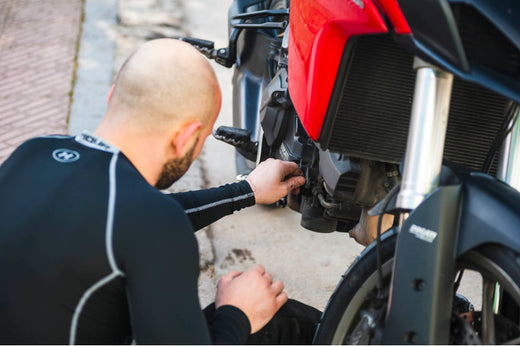 motocyklista dokonujący sprzwdzenia motocykla
