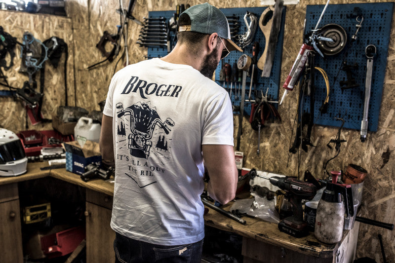 mężczyzna w warsztacie motocyklisty w białej koszulce Broger