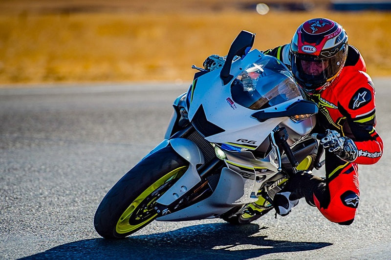 motocyklista jedzie po torze, ma założony czerwony kombinezon a na głowie kask sportowy bell star mips