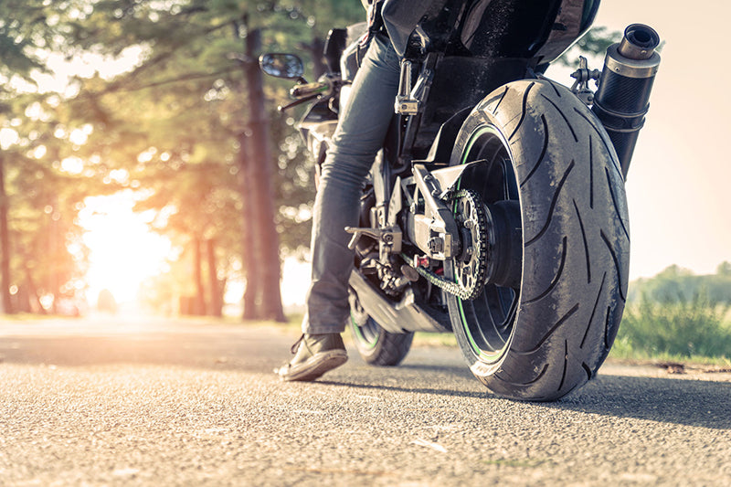 motocykl ze zbliżeniem na tylną oponę przy zachodzie słońca