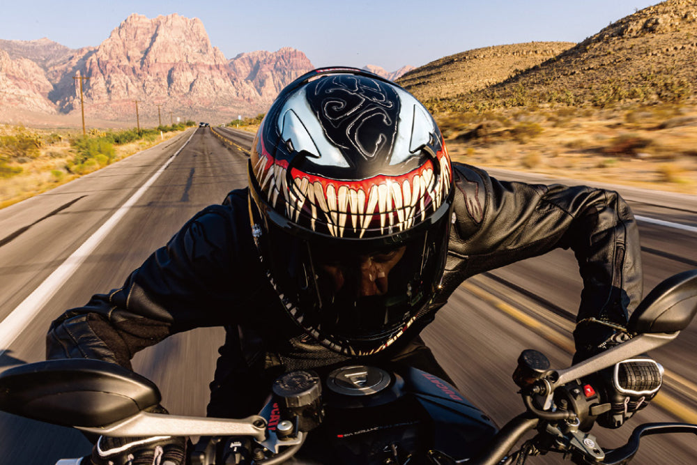 motocyklista w kasku malowanym Venom