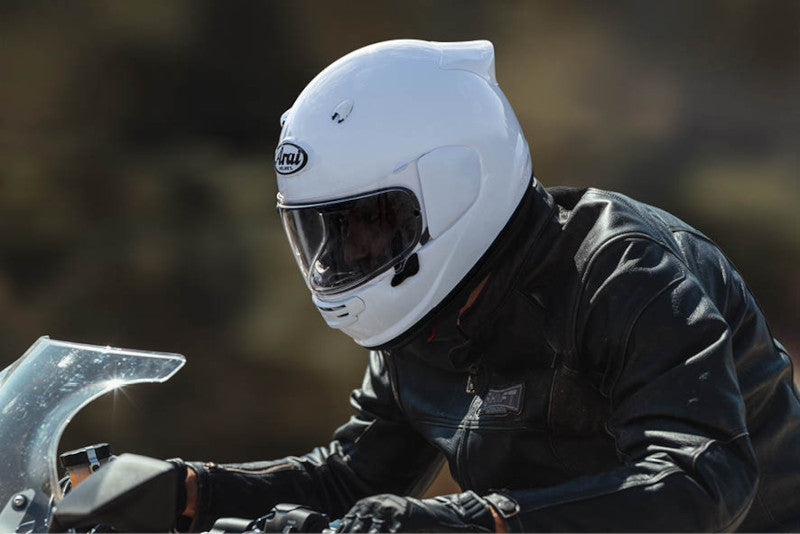 motocyklista jadący w białym kasku Arai