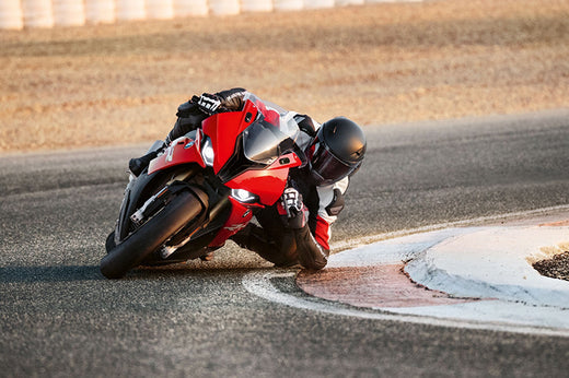 motocyklista na motocyklu BMW podczas zakretu na torze