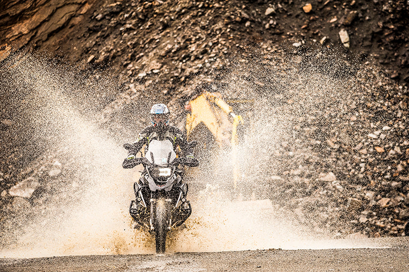 Motocyklista w komplecie Rebelhorn Patrol przejeżdza przez mokry teren