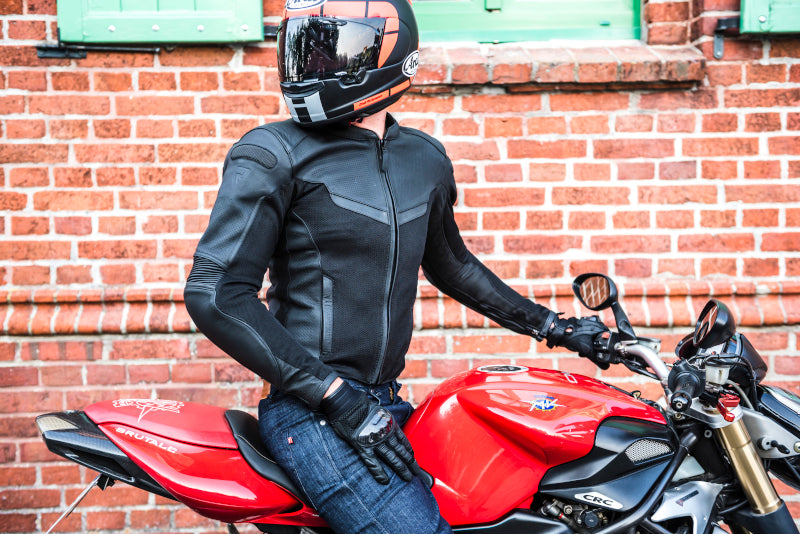 Motocyklista siedzący na motocyklu pozuje do zdjęcia