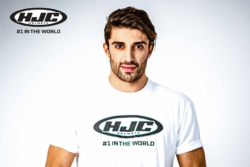 Andrea Iannone pozujący na białym tle w koszulce z logiem HJC