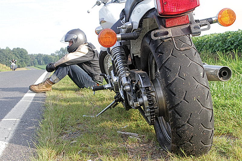 motocyklista czeka na pomoc, w kole motocyklowym nie ma powietrza