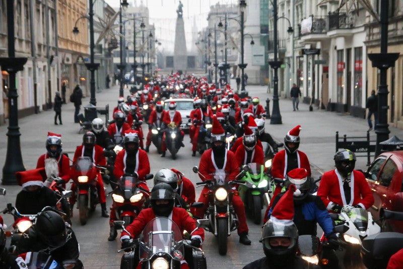 Parada MotoMikołaje na motocyklach w mieście w tle ulica i przechodnie, przebrania mikołajów i motocykle