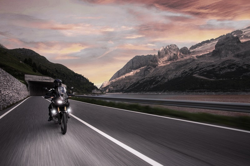 Motocyklista jedzie na motocyklu nocą wyposażony w akcesoryjne lamp SW-Motech Evo