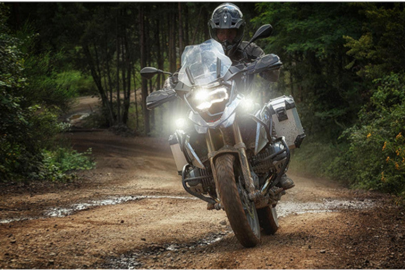 Motocyklista na motocyklu z kuframi w lesie