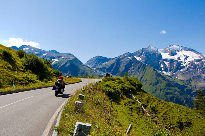motocyklista jadący drogą w Alpach