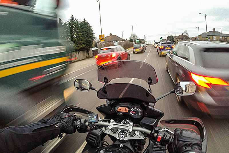 motocyklista pomiędzy samochodami w mieście