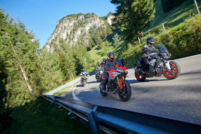 turyści motocyklowi jadący na dłuższą wyprawę po górskiej szosie, mają założone rękawice motocyklowe held air-n-dry