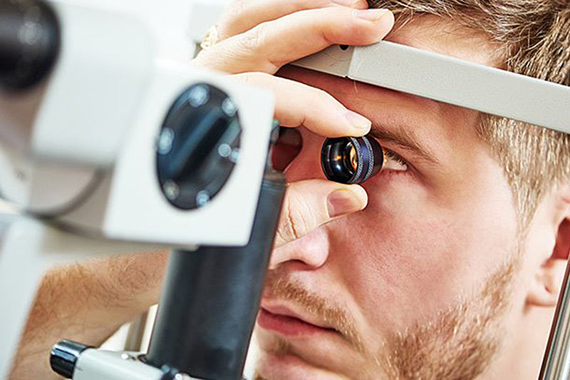 Badanie wzroku młodego mężczyzny specjalną aparaturą