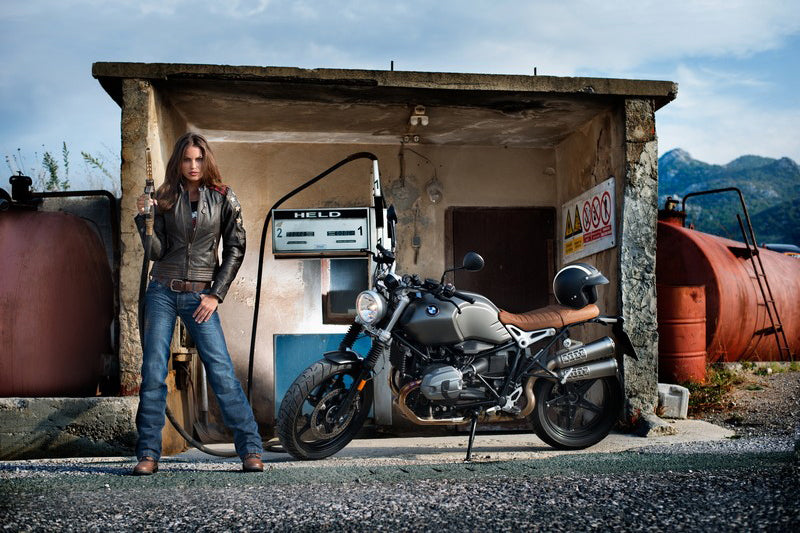 kobieta stoi na starej stacji motocyklowej obok motocykla bmw