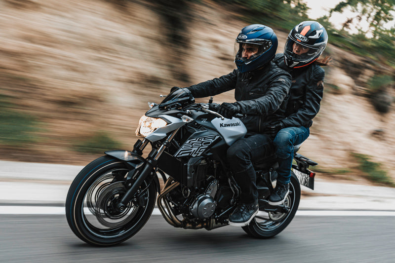 motocykliści jadą drogą asfaltową w kaskach HJC na motocyklu Kawasaki