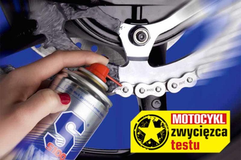 spray do czyszczenia i konserwacji łańcucha, ręka spryskująca łańcuch specjalistyczną chemią motocyklową