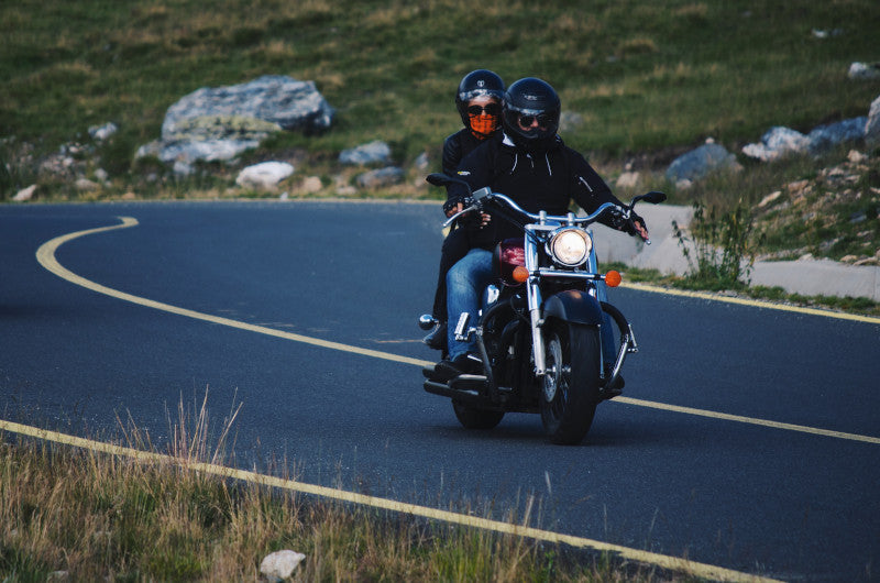 motocyklista jedzie drogą z plecakiem