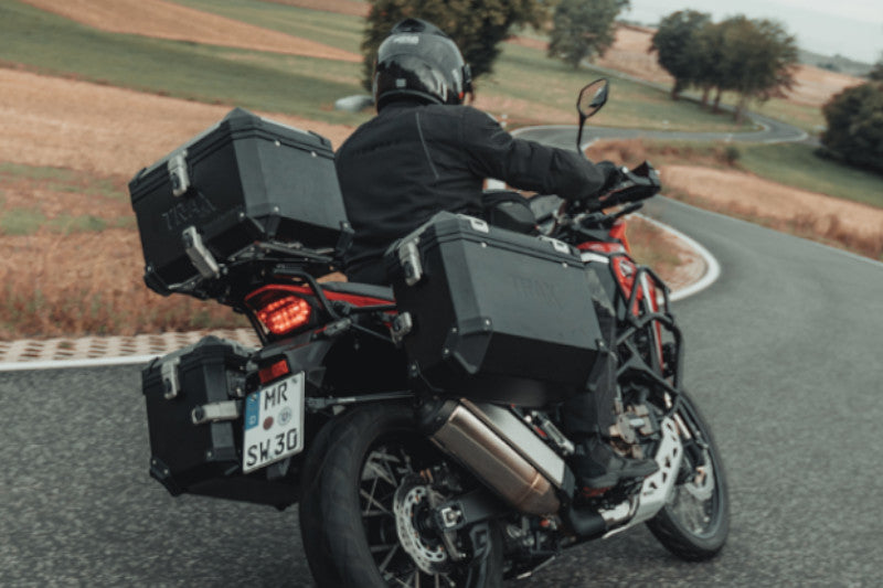 motocyklista jadący na motocyklu ubranym w kufry motocyklowe sw-motech trax