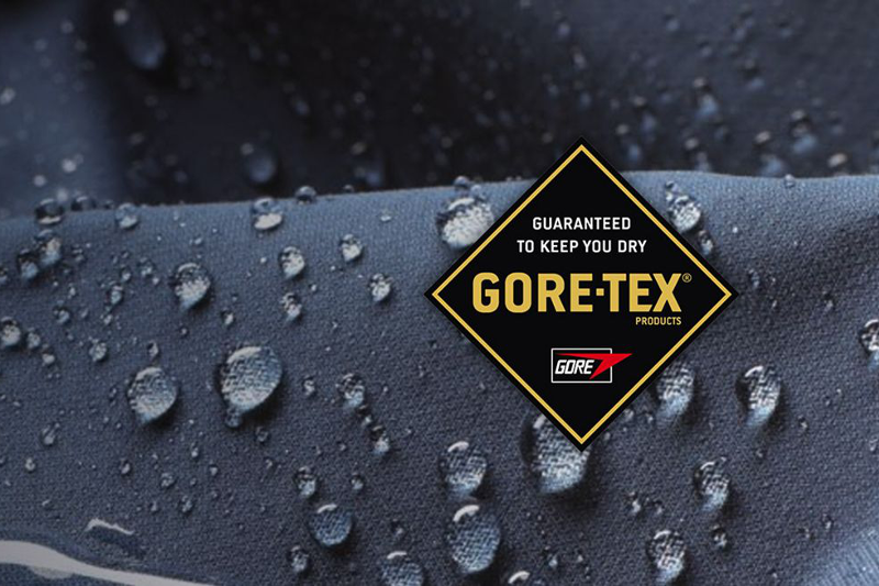 Logo Gore-TEX z hasłem marki, na ciemnym tle z kroplami wody