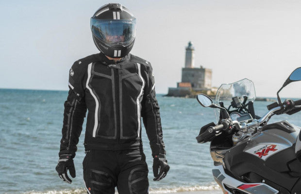 Motocyklista stoi ubrany w kurtce Held Aerosec obok motocykla