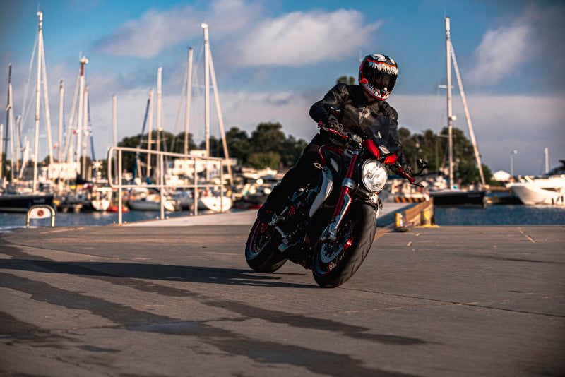 motocyklista ubrany na czarno skręca jadąc przez port