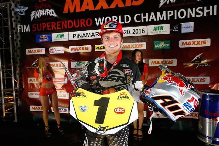 Jonny Walker na SIM Superenduro World Championship pozujący do zdjęcia z nagrodą, trzymając kask motocyklowy