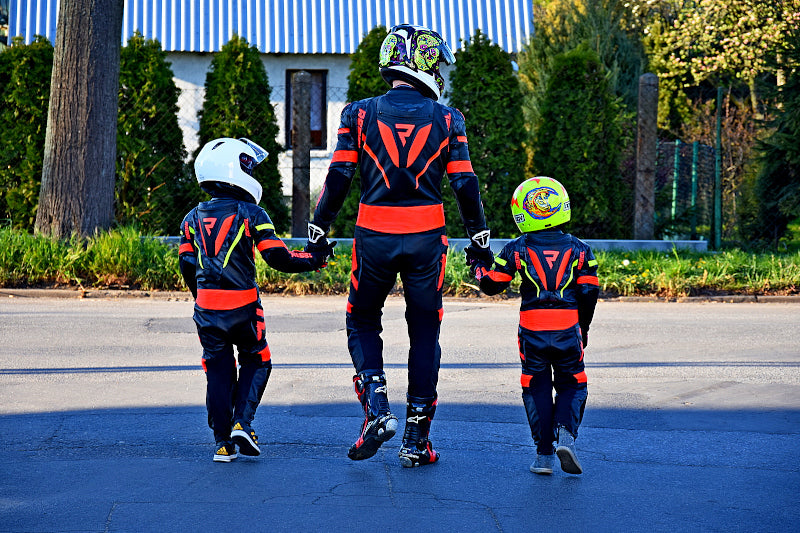 Osoba dorosła w kombinezonie motocyklowym marki Rebelhorn wraz z dwóją dzieci ubranych w kombinezony motocyklowe RebelHorn zdjecie zrobione od tyłu
