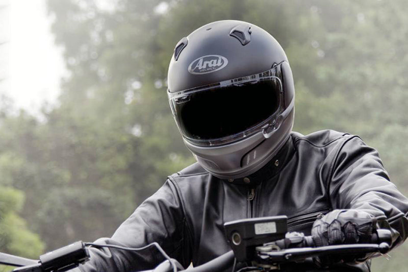 motocyklista ubrany na czarno w kasku Arai