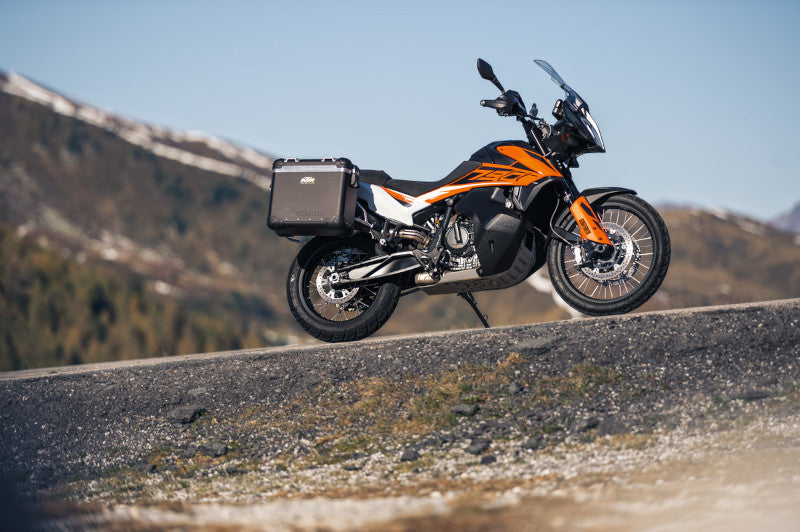 Motocykl KTM 790 Adventure R stojący na drodze szutrowej, w tle góry