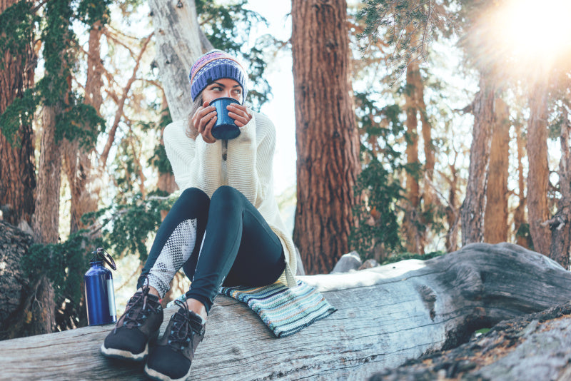 dziewczyna w czasie hikingu pije kawę z dobrego kubka termicznego
